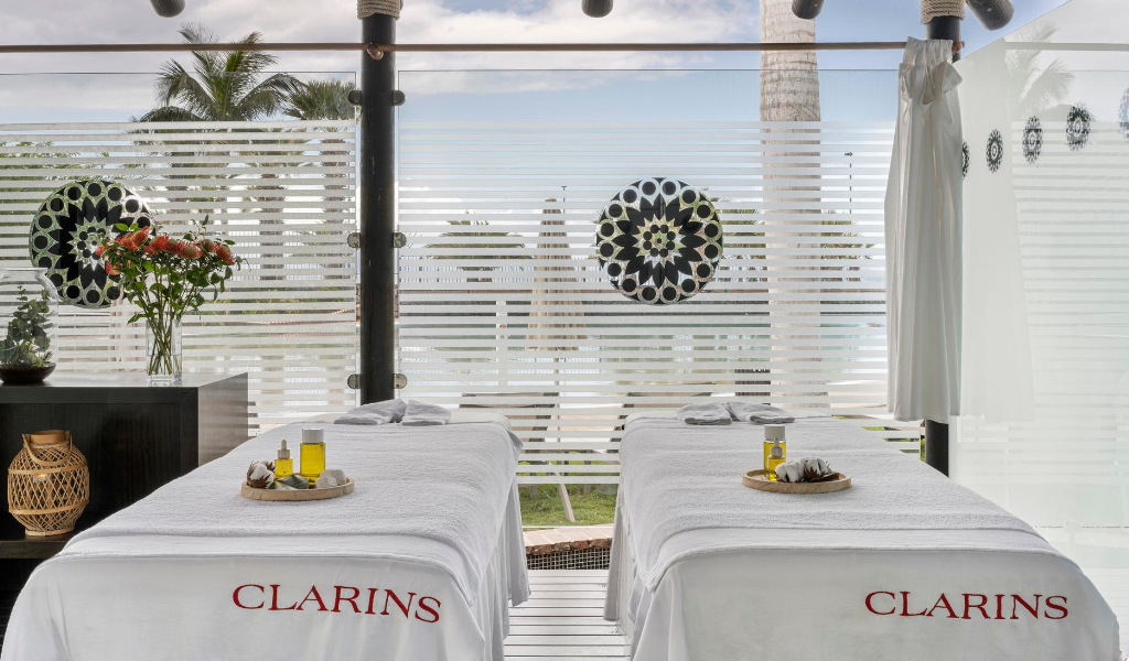 Massage table with oils in Clarins spa, Tenerife, next to a decorated window.