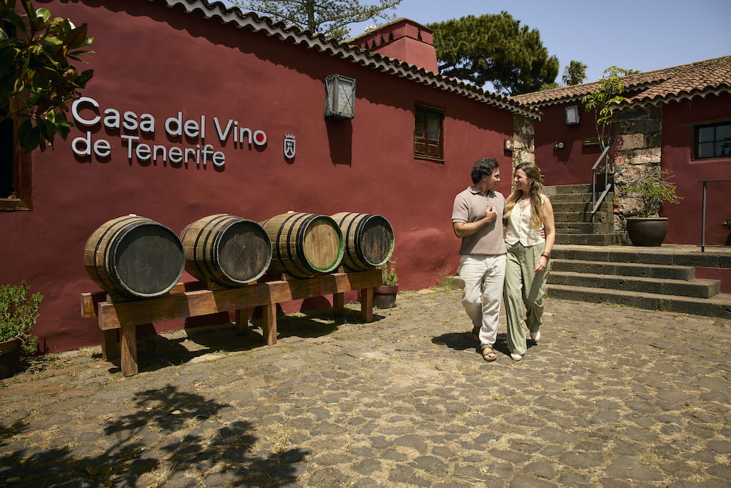 Couple walking next to barrels at the Casa del Vino de Tenerife.