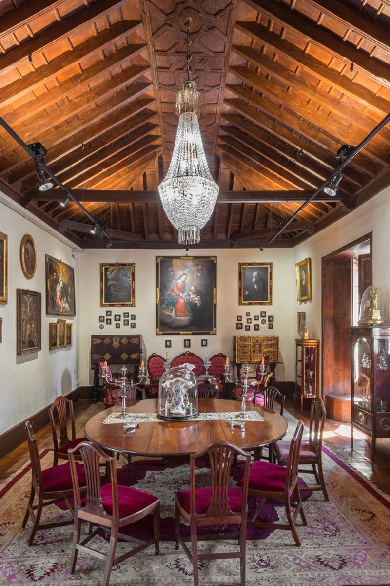 Dining room with chandeliers, round table and wooden ceiling, in Tenerife.