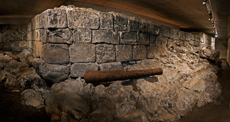 Ruins of a historic wall in Tenerife illuminated under a concrete roof.