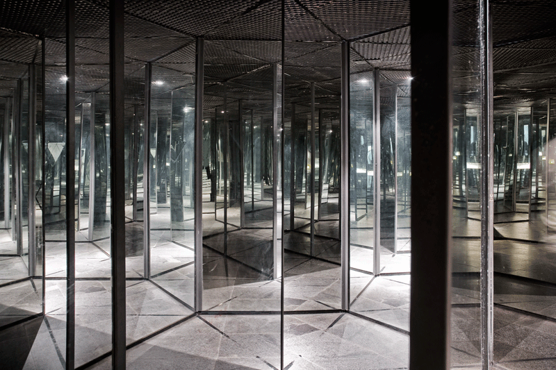 Corridor of mirrors creating multiple reflections in a labyrinth.
