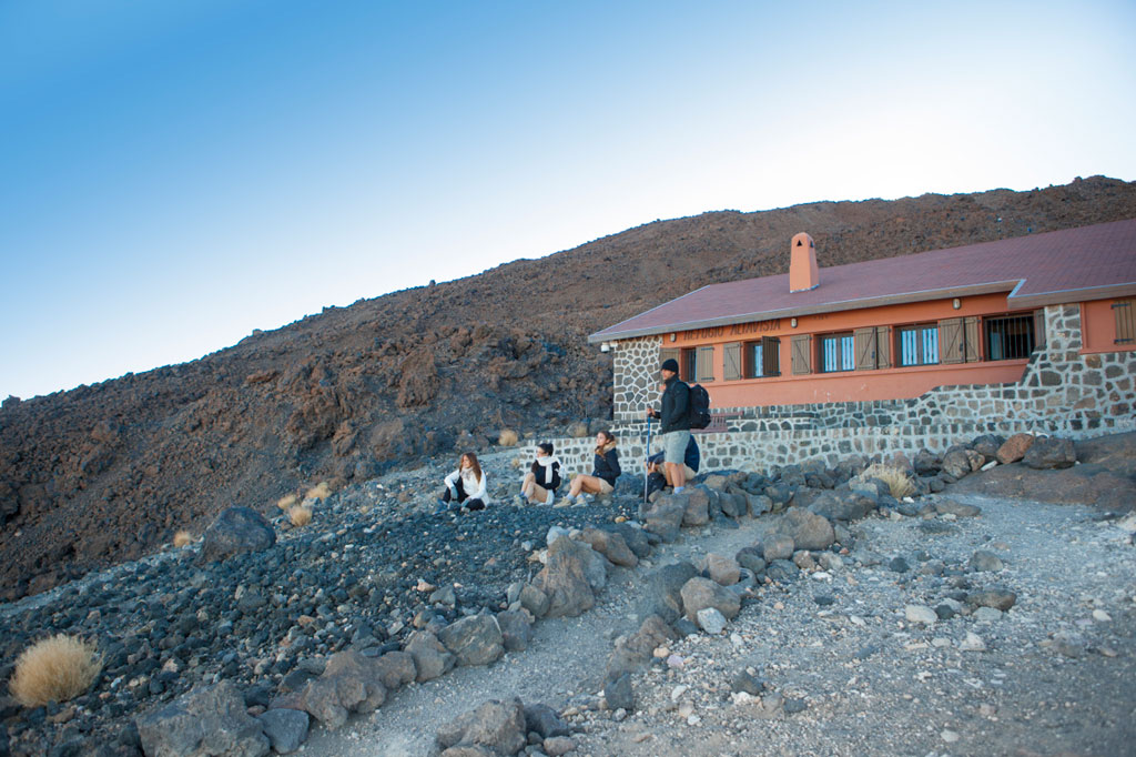 People resting in front of the Altavista Refuge in the Teide National Park, Tenerife.