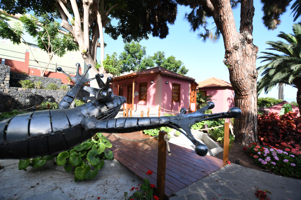 Metallic lizard sculpture in front of a pink house in Puerto de la Cruz, Tenerife.
