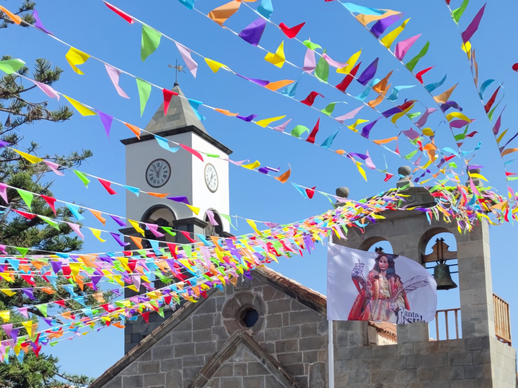 Church tower in Tenerife with colorful pennants and flag of Santa Úrsula.