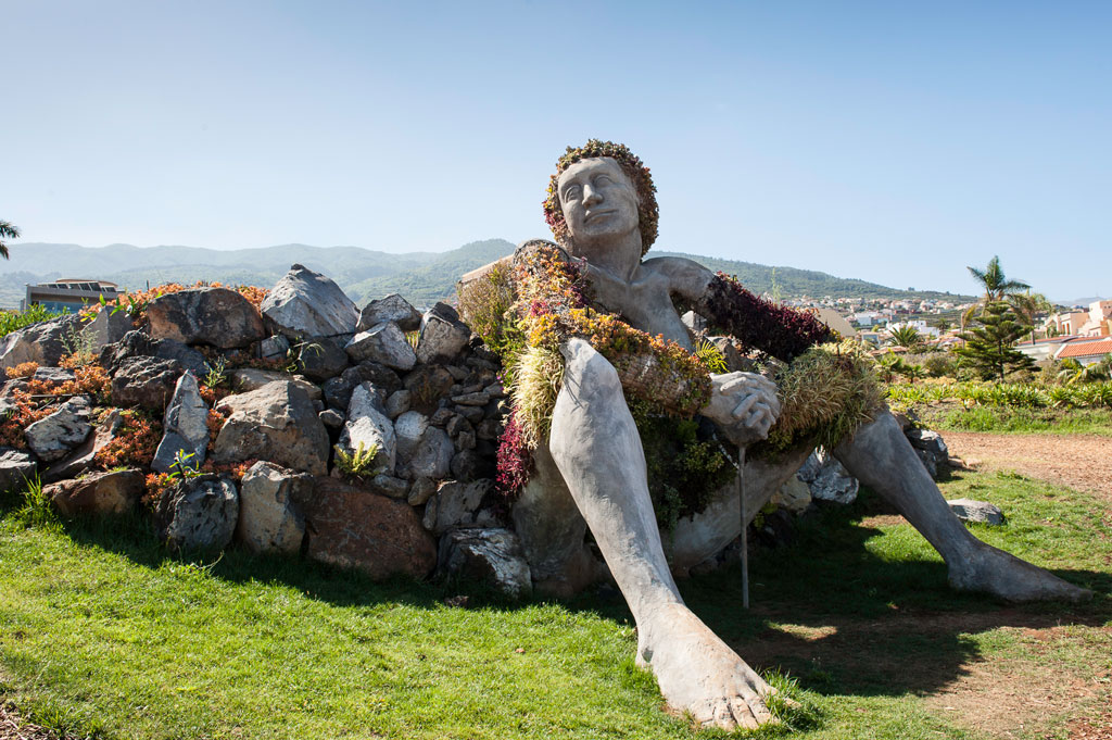 Sculpture of a seated woman covered in plants in a park in Tenerife.