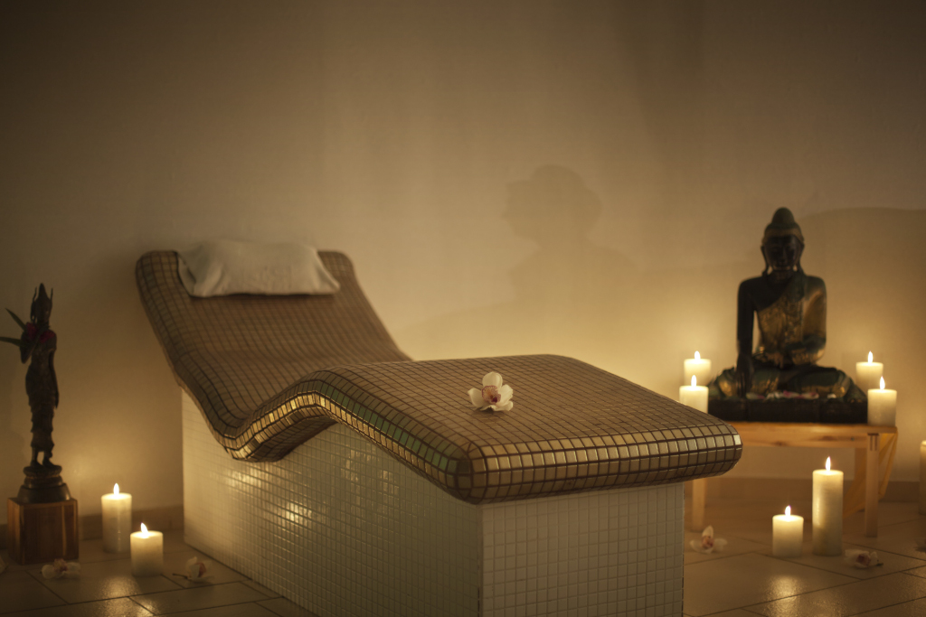 Massage table with candles and statue in spa in Tenerife.