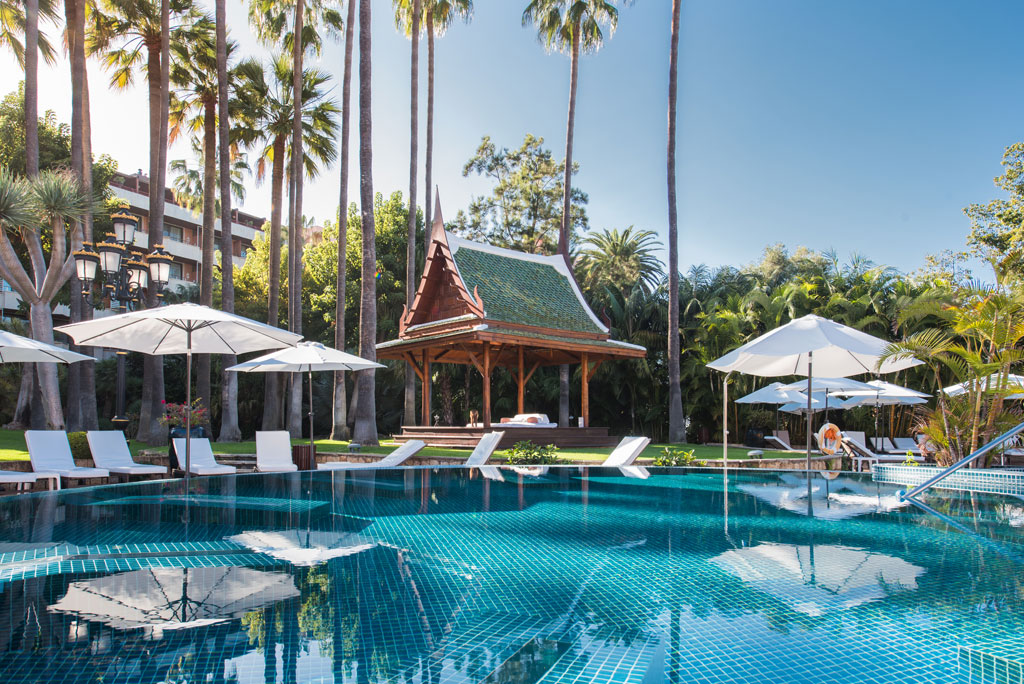 Swimming pool with parasols and oriental-style cabana in a hotel in Tenerife.