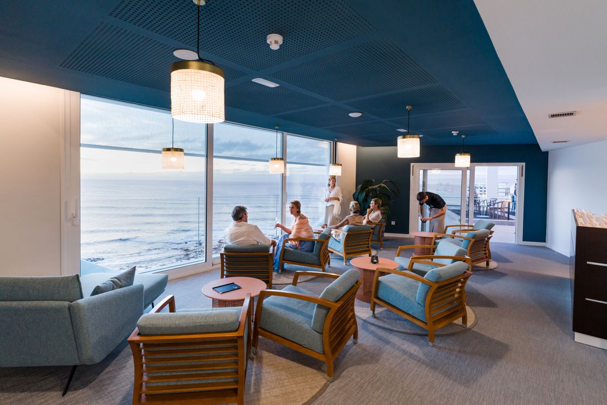 People chat in a lounge overlooking the sea in Tenerife.