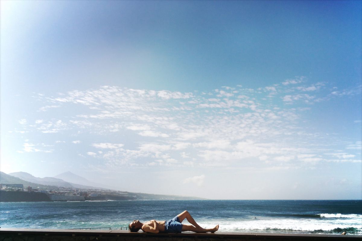 Person resting by the sea in Puerto de la Cruz, Tenerife.