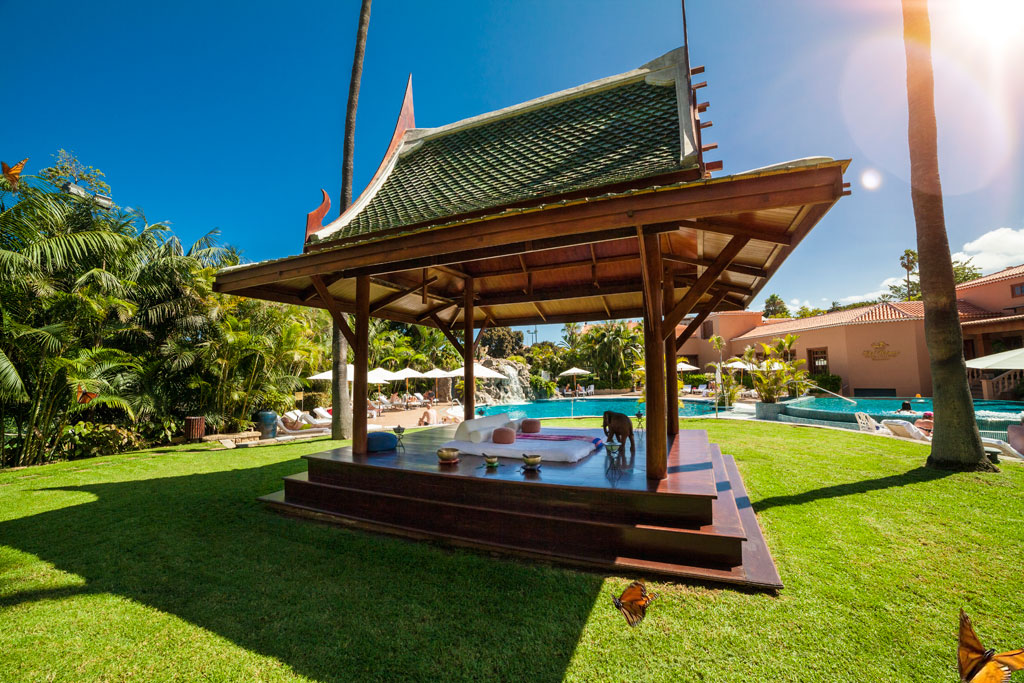 Wooden pavilion in garden with swimming pool in Tenerife hotel.