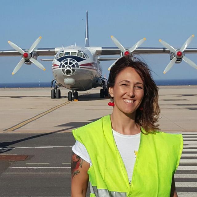 A person wearing a reflective vest in front of an airplane on the tarmac of Tenerife airport.